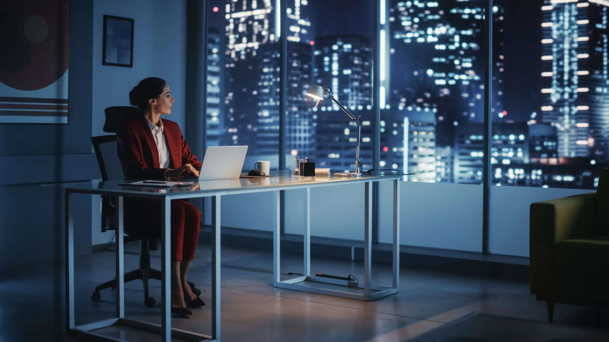 A business woman working at her desk at night.